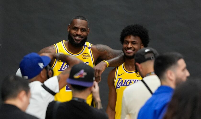 LeBron James und sein Sohn Bronny lächeln im gelben Lakers-Trikot für die Fotografen