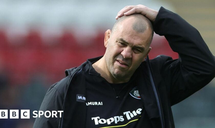 Leicester Tiger's Michael Cheika has his hand on his head while walking off the pitch