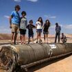 Defiant children play on wrecked rocket in the Israeli desert - as IDF gears up to strike Iran nuclear sites 'within days'