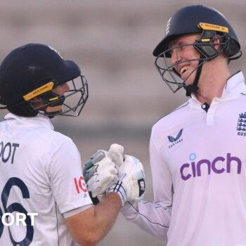 Zak Crawley and Joe Root clench gloves in the first Test against Pakistan