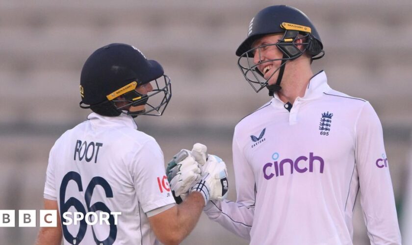 Zak Crawley and Joe Root clench gloves in the first Test against Pakistan