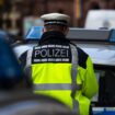 Straftäter gefasst: Ein Polizeibeamter steht zwischen zwei Einsatzfahrzeugen.