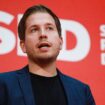 Kevin Kühnert spricht vor einer roten Wand mit weißem Logo der SPD