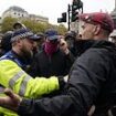 Tommy Robinson supporters chant 'We want Tommy out!' as their figurehead is held in a police cell - while police clash with protesters on both sides and violent demonstrators are arrested