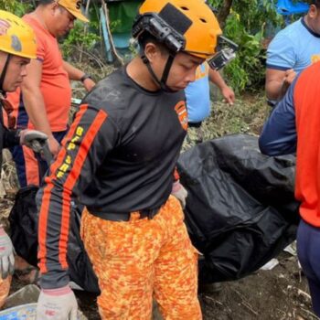 Rettungskräfte bergen eine Leiche nach einem Erdrutsch, der durch den Tropensturm Trami ausgelöst wurde Foto: Jim Gomez/AP/dpa