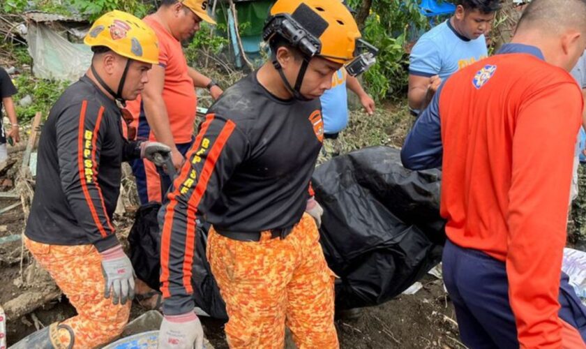 Rettungskräfte bergen eine Leiche nach einem Erdrutsch, der durch den Tropensturm Trami ausgelöst wurde Foto: Jim Gomez/AP/dpa