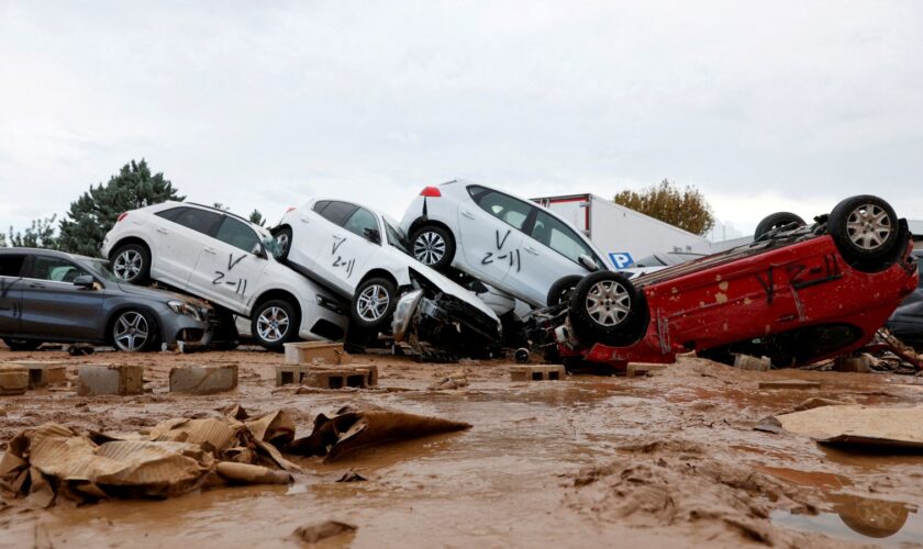 Vehicles marked by firefighters, with a code indicating that they have searched for casualties from the floods in Paiporta. Pic: Reuters