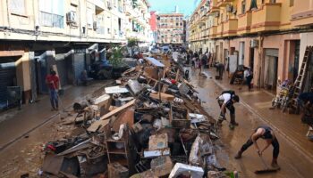 Des habitants empilent des débris dans une rue de Paiporta, après des inondations dévastatrices, le 1er novembre 2024 dans la région de Valence, en Espagne