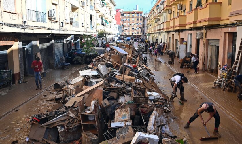 Des habitants empilent des débris dans une rue de Paiporta, après des inondations dévastatrices, le 1er novembre 2024 dans la région de Valence, en Espagne