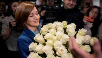 Maia Sandu holds a bouquet of flowers while standing with her supporters on election night. Pic: AP