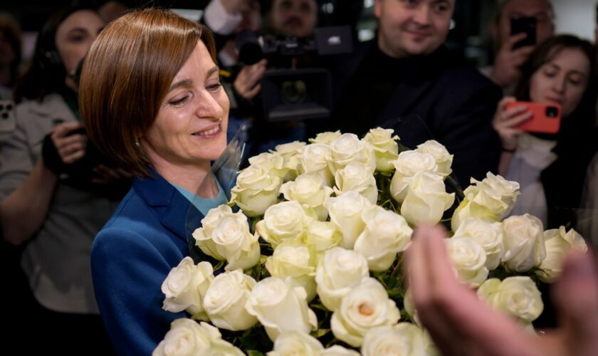 Maia Sandu holds a bouquet of flowers while standing with her supporters on election night. Pic: AP