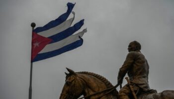 A Cuban flag shredded by the winds of Hurricane Rafael flies above the statue of General Calixto Garcia in Havana, Cuba Pic: AP