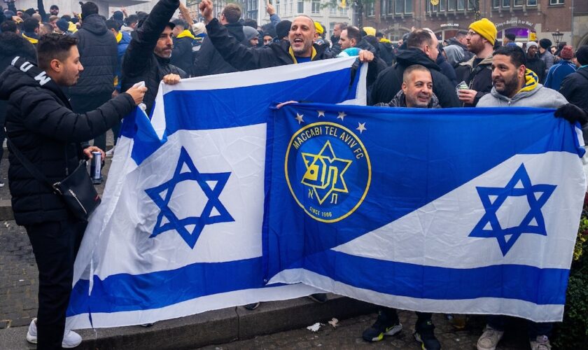 Les supporters du Maccabi Tel Aviv brandissent des drapeaux sur la place du Dam avant le match de football de la Ligue Europa entre l'Ajax et le Maccabi Tel Aviv, à Amsterdam, le 7 novembre 2024