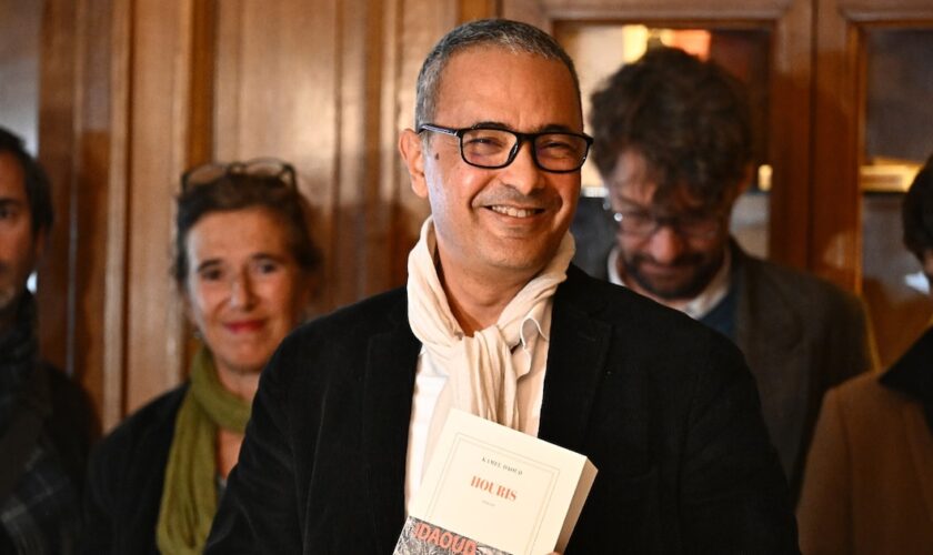 L'écrivain franco-algérien Kamel Daoud (c), lauréat du prix Goncourt pour son roman "Houris", au restaurant Drouant à Paris, le 4 novembre 2024