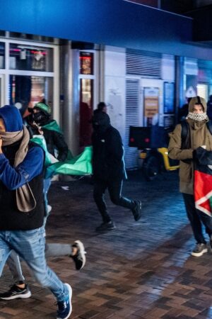 Des manifestants courent avec des drapeaux palestiniens lors d'une manifestation pro-palestinienne pendant Ajax - Maccabi Tel-Aviv à Anton de Komplein.