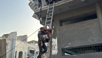 Un Palestinien porte secours à une femme blessée par une frappe dans le camp de réfugiés de Jabalia, dans le nord de la bande de Gaza, le 7 novembre 2024