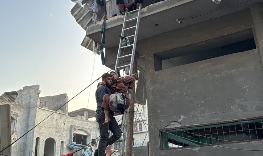 Un Palestinien porte secours à une femme blessée par une frappe dans le camp de réfugiés de Jabalia, dans le nord de la bande de Gaza, le 7 novembre 2024