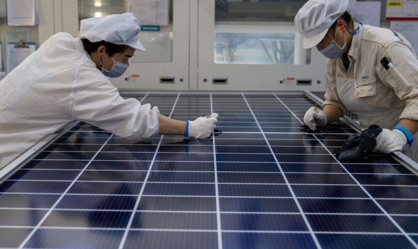 Des ouvriers produisent des modules solaires photovoltaïques dans l'atelier de GCL Integrated New Energy Technology Co. Ltd. dans le parc de démonstration de l'économie circulaire de Hefei dans le comté de Feidong, à Hefei, dans la province de l'Anhui, le 16 octobre 2024. (Photo by Costfoto/NurPhoto) (Photo by CFOTO / NurPhoto / NurPhoto via AFP)