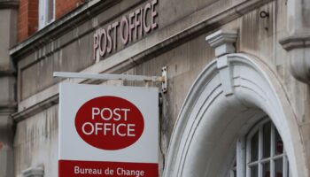 A post office sign hangs above a shop