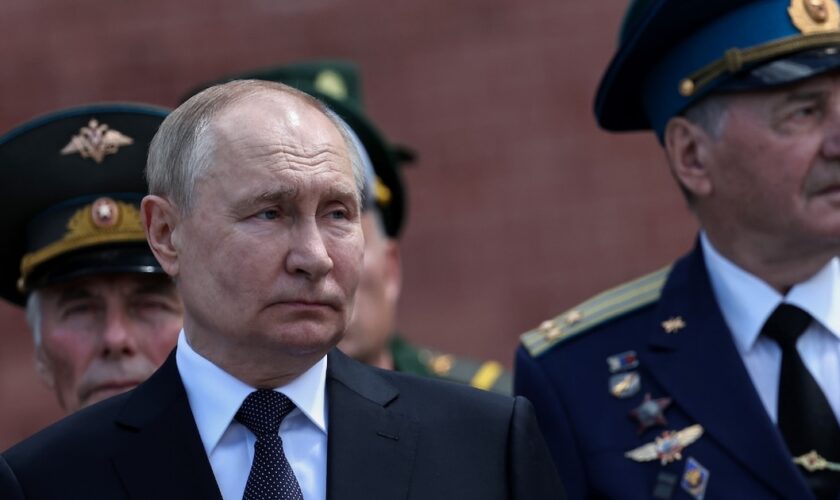 Le président russe Vladimir Poutine (g) participe à une cérémonie de dépôt de gerbes sur la tombe du Soldat inconnu près du mur du Kremlin, le 22 juin 2024 à Moscou