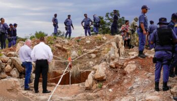 Police officers and private security personnel at the entrance to the mine in Stilfontein, South Africa. Pic: AP/Denis Farrell