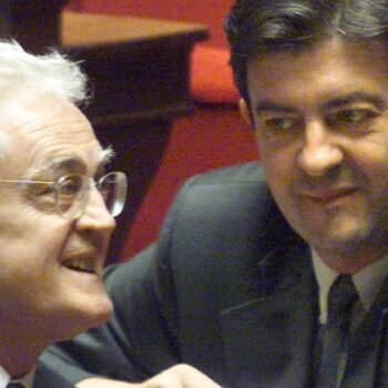 Le 28 mars 2000, le nouveau ministre de l'Enseignement professionnel, Jean-Luc Mélenchon (D), écoute le Premier ministre Lionel Jospin,  dans l'hémicycle de l'Assemblée nationale à Paris, lors de la séance des questions au gouvernement, au lendemain du remaniement ministériel. (Photo by JOEL SAGET / AFP)