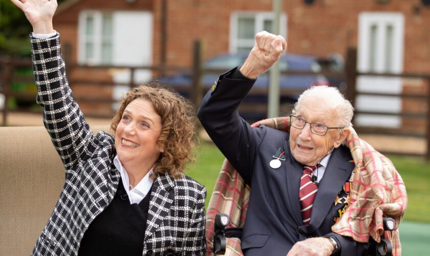 Handout photo of Second World War veteran Captain Tom Moore with his daughter Hannah, as they wave to a Battle of Britain Memorial Flight flypast of a Spitfire and a Hurricane passing over his home as he celebrates his 100th birthday.