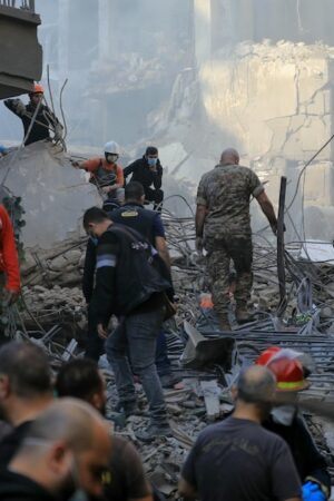 Des sauveteurs dans les décombres de bâtiments détruits par une frappe israélienne dans le quartier de Basta à Beyrouth, le 23 novembre 2024 au Liban