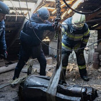 In this photo provided by the Ukrainian Emergency Service, emergency services personnel remove part of a Russian missile that hit an apartment house during massive missile attack in Kyiv, Ukraine, Sunday, Nov. 17, 2024. (Ukrainian Emergency Service via AP)