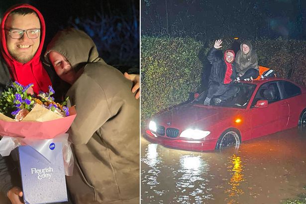 Bizarre moment boyfriend proposes to partner on roof of their car during flood