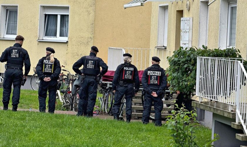 Fünf Polizistinnen und Polizisten stehen vor einem Haus