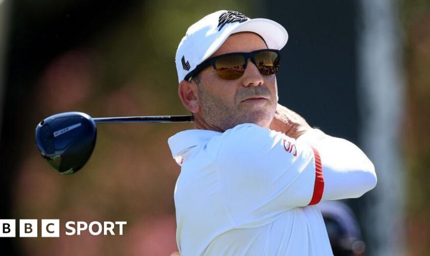 Sergio Garcia in sunglasses with a golf club after taking a shot