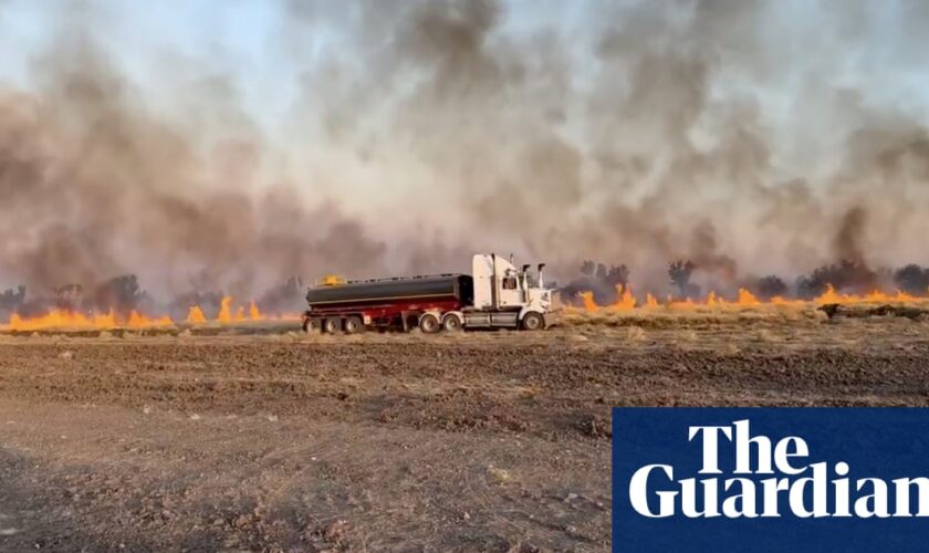 Heatwave sweeps across large parts of Australia as bushfire threatens Queensland border town