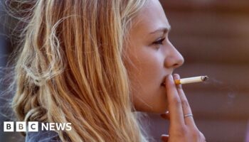 Blonde woman smoking cigarette - stock photo