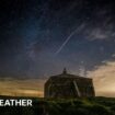 Church building in foreground with a shooting star streaking across the night sky beyond