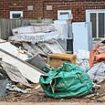 Man who turned front garden into a makeshift tip with tonnes of rubbish is KICKED OUT of his home by council after neighbour complained it made their children sick