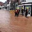 Shocking moment floodwaters gush down streets of market town as emergency service crews urge locals to 'get back': Death toll for Storm Bert rises to four 