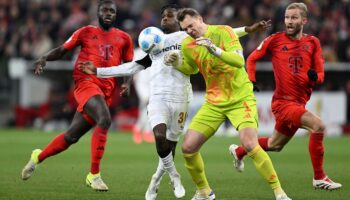 Manuel Neuer kommt zu spät und rammt Leverkusens Jeremie Frimpong um. Foto: Sven Hoppe/dpa