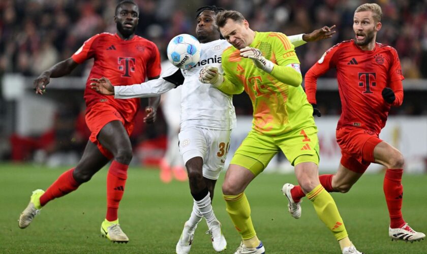 Manuel Neuer kommt zu spät und rammt Leverkusens Jeremie Frimpong um. Foto: Sven Hoppe/dpa