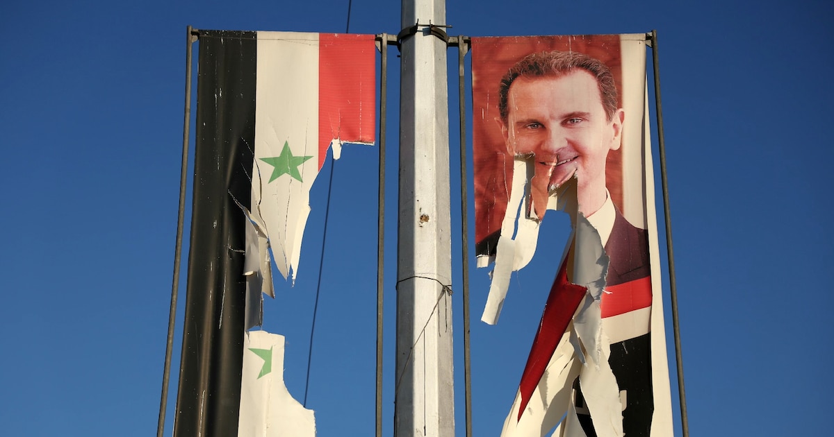 Un drapeau national syrien et un portrait du président syrien Bachar al-Assad dséchirés par des combattants antigouvernementaux dans la ville d'Alep, dans le nord de la Syrie, le 30 novembre 2024