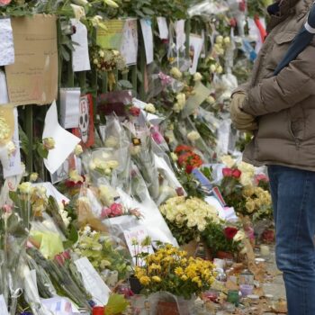 Un homme avec un drapeau tricolore le 27 novembre 2015 devant le Bataclan à Paris