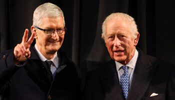 Tim Cook,CEO of Apple, gestures next to Britain's King Charles during their visit at Apple's UK Head Office at Battersea Power Station in London, Britain, December 12, 2024. REUTERS/Toby Melville