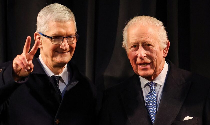 Tim Cook,CEO of Apple, gestures next to Britain's King Charles during their visit at Apple's UK Head Office at Battersea Power Station in London, Britain, December 12, 2024. REUTERS/Toby Melville