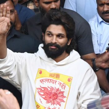 Indian Southern film actor Allu Arjun, center, greets his fans  in Hyderabad, India, Friday, Dec. 13, 2024, as he leaves a hospital where he was taken for medical checkup by policemen before arresting him after his appearance at a film screening allegedly led to a crush of fans in which a woman died. (AP Photo)