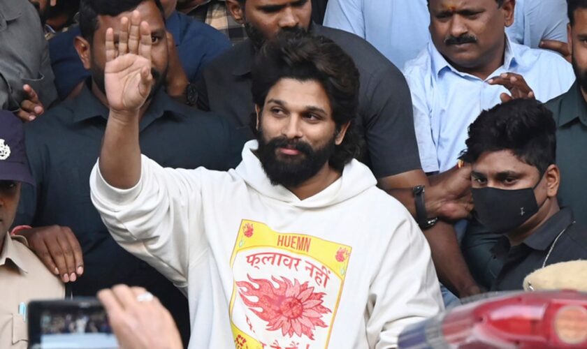 Indian Southern film actor Allu Arjun, center, greets his fans  in Hyderabad, India, Friday, Dec. 13, 2024, as he leaves a hospital where he was taken for medical checkup by policemen before arresting him after his appearance at a film screening allegedly led to a crush of fans in which a woman died. (AP Photo)