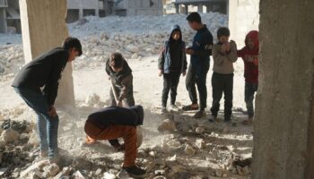 Children dig up bones where at least 41 murdered in Syria pit massacre