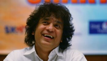 FILE - Indian Tabla expert Zakir Hussain laughs during a press conference to announce a musical concert in Mumbai, India, on Dec 8, 2006. (AP Photo/Rajesh Nirgude, File)