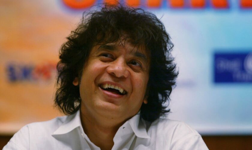 FILE - Indian Tabla expert Zakir Hussain laughs during a press conference to announce a musical concert in Mumbai, India, on Dec 8, 2006. (AP Photo/Rajesh Nirgude, File)