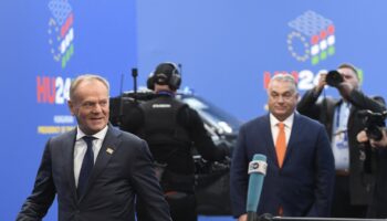 Le Premier ministre polonais Donald Tusk arrive sous les yeux du Premier ministre hongrois Viktor Orban (R) pour participer à la réunion informelle des chefs d'État ou de gouvernement de l'Union européenne à Budapest, le 8 novembre 2024. (Photo Ferenc ISZA / AFP)