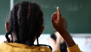 Une élève de primaire lève le doigt pour parler, lors de la rentrée à l'école Pergaud, à Mulhouse, le 4 septembre 2023.